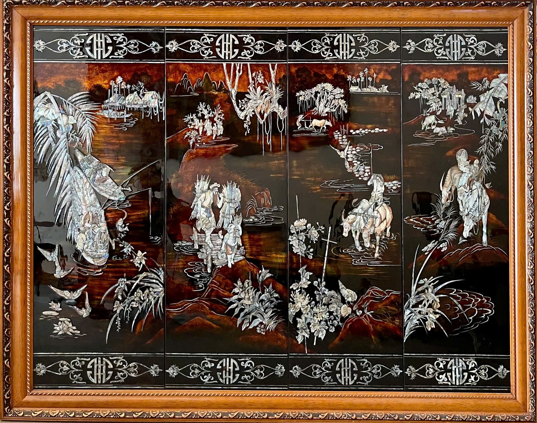 Thiên hạ thái bình — A framed four-panel landscape unfolds through figures, animals, waterways and distant buildings. Pale details stand out against the dark, warm-toned ground.