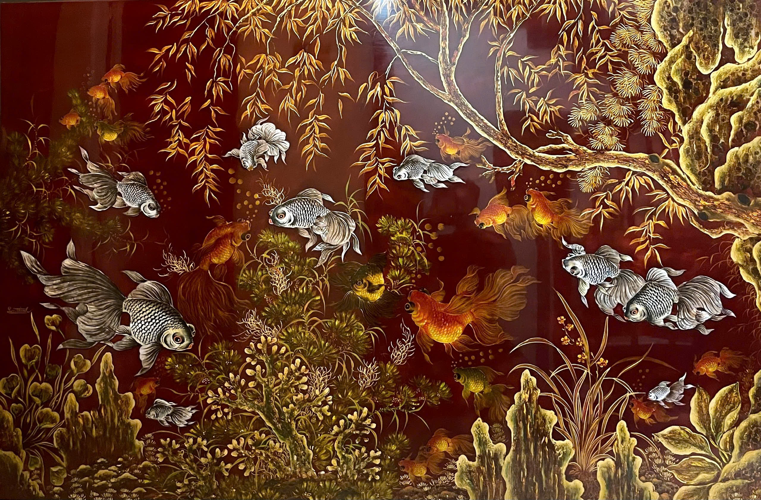 Ngư tảo (cẩn ốc) — Silver-toned and orange fish move beneath willow branches in this wide red-ground composition. Shell inlay is recorded in the supplied catalog title.